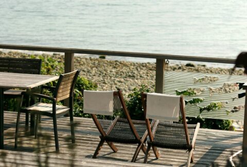 two sunbeds facing the sea on a wooden patio