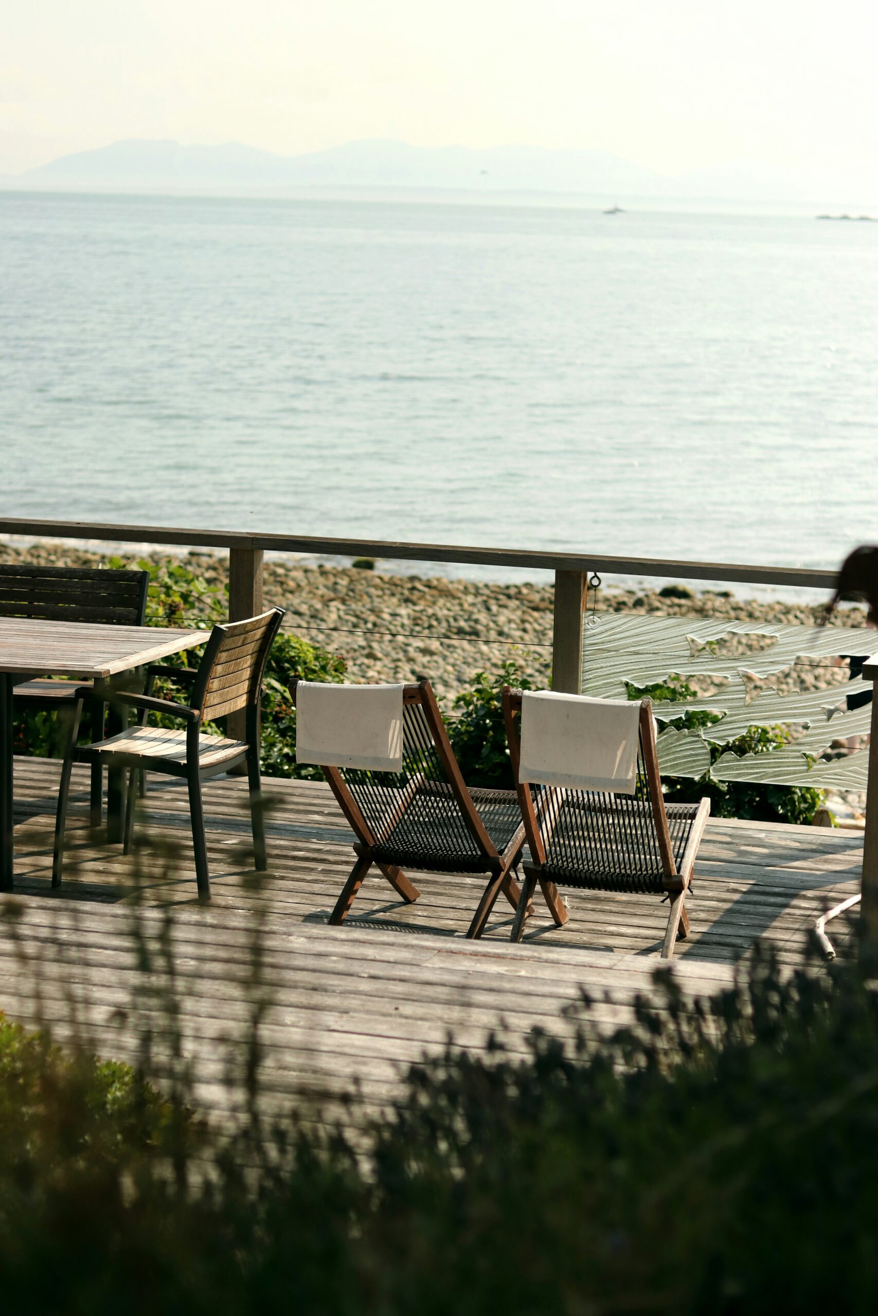 two sunbeds facing the sea on a wooden patio