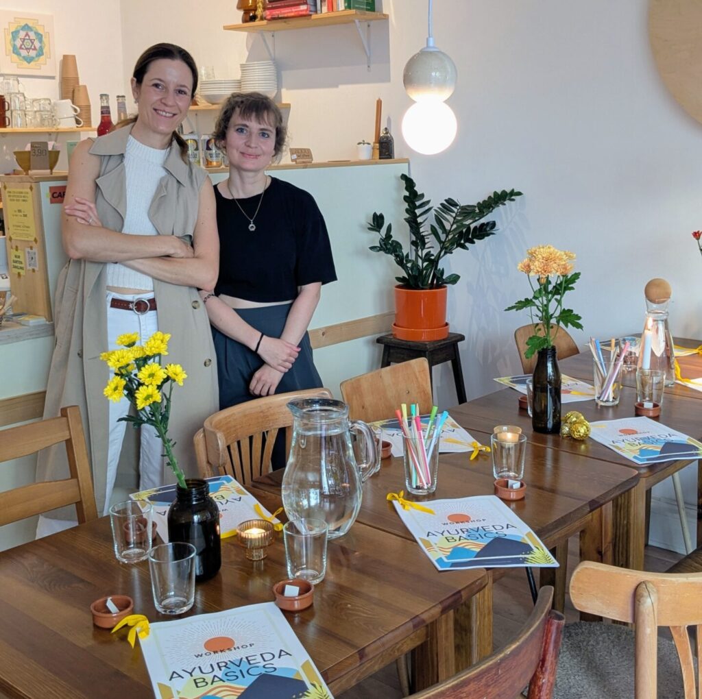 two women standing behind of a table prepared for a workshop
